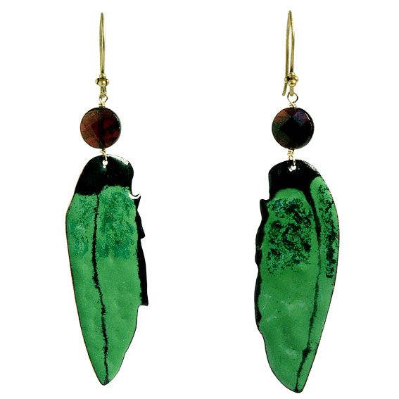 A pair of green leaf-shaped earrings with a gold hook and dark circular stones above.