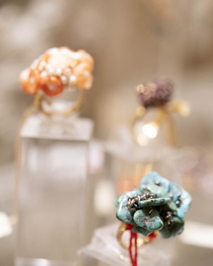 Bague ornée de perles roses sur un support en verre.