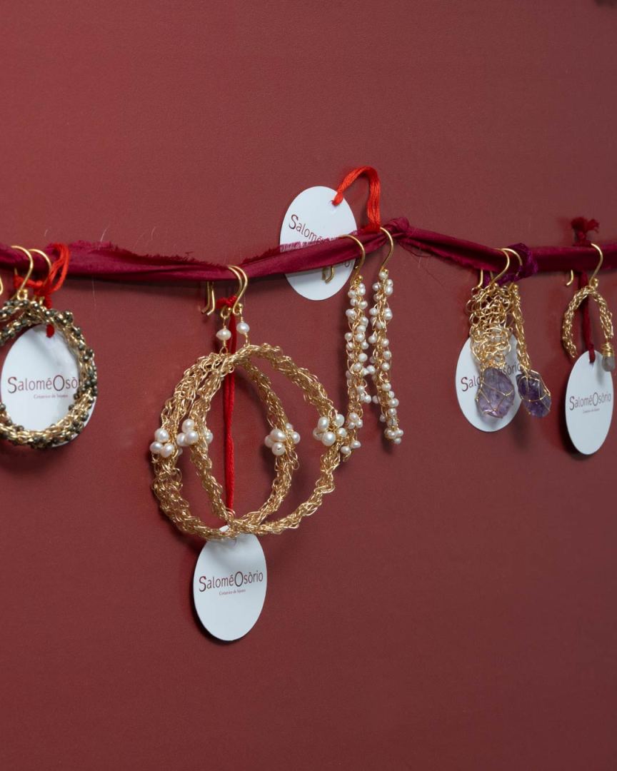 Collection de boucles d'oreilles suspendues sur un fil, avec des étiquettes portant le nom 'Salomé Osorio'.