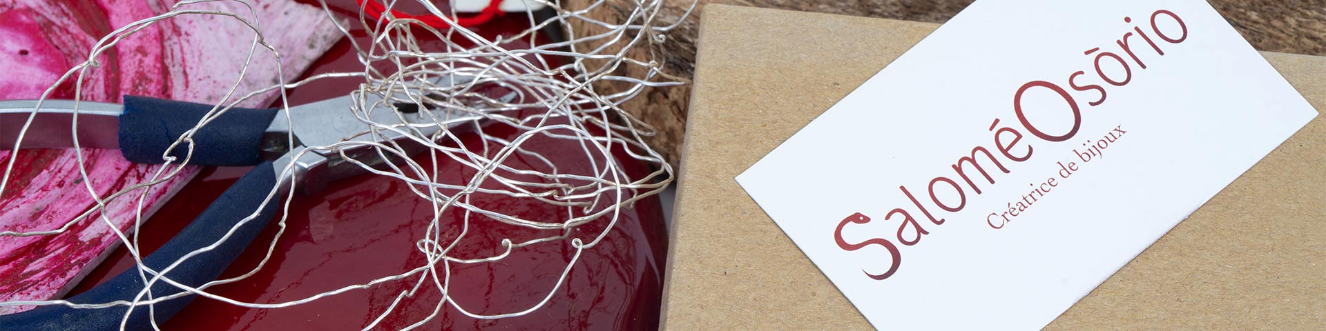 Image d'un outil de bijouterie sur un fond coloré, avec un carton portant le nom de la marque Salomé Osório.